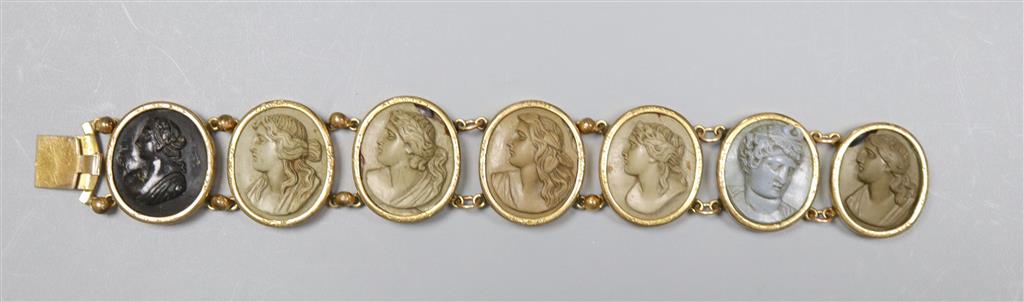 A Victorian gilt metal and lava bracelet, set with seven oval panels carved with busts of ladies and gentleman, 17.2cm.